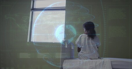 Fototapeta premium Sitting girl wearing printed medical gown on exam table facing window, digital globe, copy space