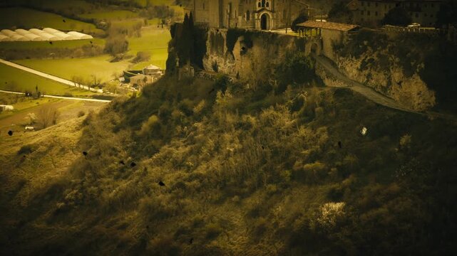 Vista a&eacute;rea cinematogr&aacute;fica del conjunto medieval de Fr&iacute;as, con etalonaje en tonos amarillos que aporta tensi&oacute;n y misterio. La arquitectura sobre la roca emerge entre sombras, evocando historia y sile