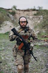 Fototapeta premium Armed Ukrainian soldier practicing his fighting skills and looking in the camera