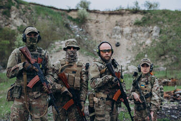Fototapeta premium Four Ukrainian soldiers with rifles looking ainthe camera at the range