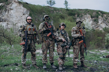 Fototapeta premium Portrait of four armed Ukrainian soldiers looking in the camera