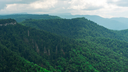 Fototapeta premium landscape rocky mountains against the sky with clouds and forests with fresh plants in spring in the north