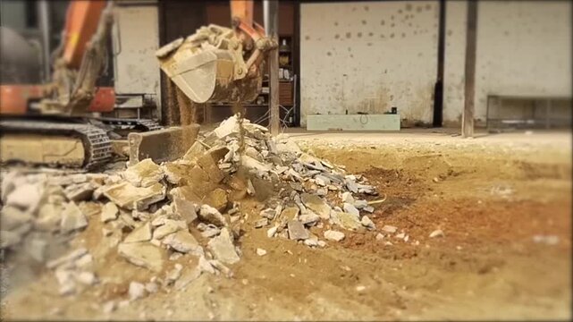 Heavy machinery excavating and moving debris, with a focus on demolition and construction processes.