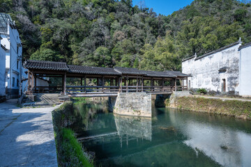 Fototapeta premium Traditional Covered Bridge Over River in Mountain Village