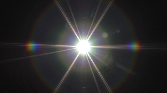 Realistic bright light glare in complete darkness, resembling a distant spotlight or camera flash