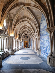 Obraz premium Corridor with Gothic arches and blue Portuguese tiles with a door at the end in Porto Cathedral, PORTUGAL