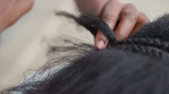 Closeup black braider creating cornrows with precise fingers, clean straight parts and rhythmic hand movements, heritage styling in focused salon environment, finished sleek look emerging