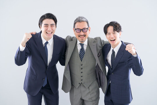 3人で並んで肩を組むスーツの日本人男性