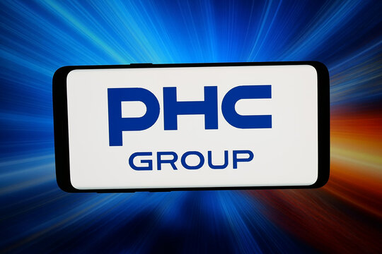 Stuttgart, Germany - 03-20-2026: In this photo illustration, the logo of healthcare company PHC Holdings Corporation is displayed on a smartphone in front of abstract background on computer screen.