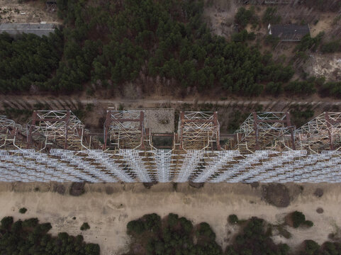 Aerial view of the massive Duga radar station lattice structure surrounded by dense pine forest in Pripyat, Kyiv Oblast, Ukraine.