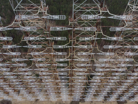 Aerial view of the massive Duga radar station steel lattice structure and dipole antennas surrounded by forest in Pryp'yat', Kyiv Oblast, Ukraine.