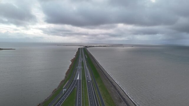 Top down static shot of dam road and passing traffic