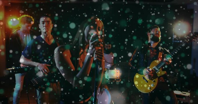 Lead singer centering after camera shift, gripping mic and leading music while particles falling