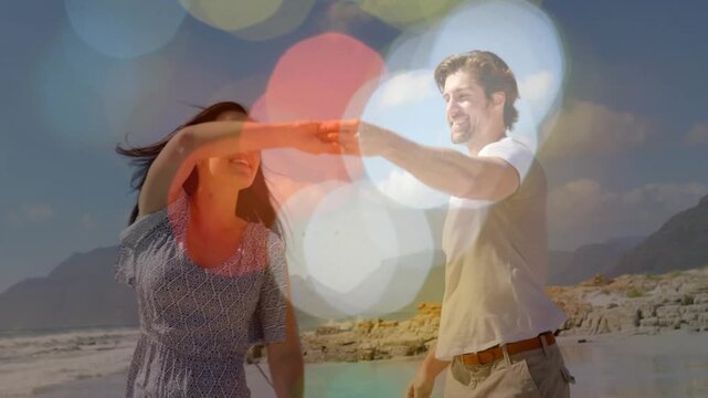 Woman lifting arm urging man spinning her holding-hands closer beach bokeh masking for fun ads