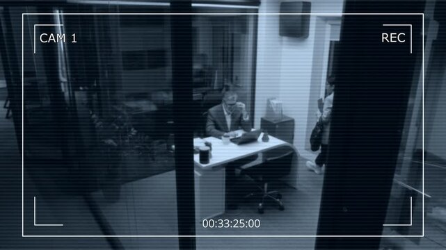 Wide overhead CCTV shot with time frame of female colleague walking into executive office to say goodbye to male manager working late in office, patting on shoulder and leaving to go home