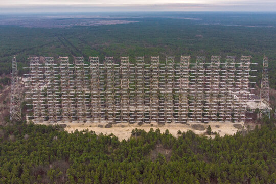 Aerial view of the massive Duga radar station antenna array surrounded by dense pine forest in Prypyat, Kyiv Oblast, Ukraine.