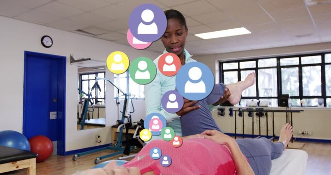 Vertical video: Therapist holding client leg and doing knee rehab, causing colorful icons rising