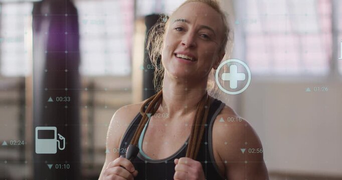 Trainer holding jump rope in gym, icons appearing after set and logging fitness stats, cam zooming