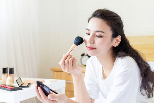 An Asian Beauty Doing Makeup in the Bedroom