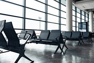 Fototapeta premium Waiting area with empty seats at an airport in daylight hours