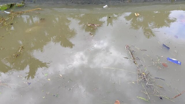 The flowing river is filled with a lot of rubbish in the rainy season