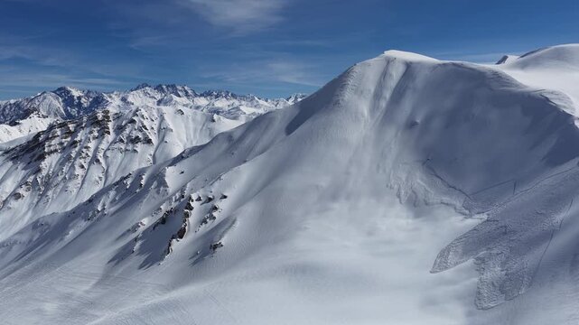 Freeride skiers climbing and descending Bidara peak in Gudauri on deep fresh powder snow, winter adventure in Georgia mountains. Backcountry freeride and skiing untouched powder in snowy mountains.