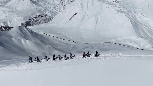 Freeride skiers climbing and descending Bidara peak in Gudauri on deep fresh powder snow, winter adventure in Georgia mountains. Backcountry freeride and skiing untouched powder in snowy mountains.