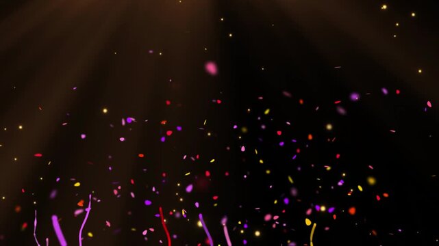 Vibrant colorful confetti and streamers falling against a dark background with a warm glow creating a festive atmosphere for celebrations