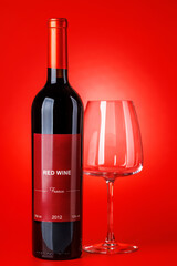 Fototapeta premium Red wine bottle mockup on red background