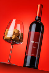 Fototapeta premium Red wine bottle mockup on red background