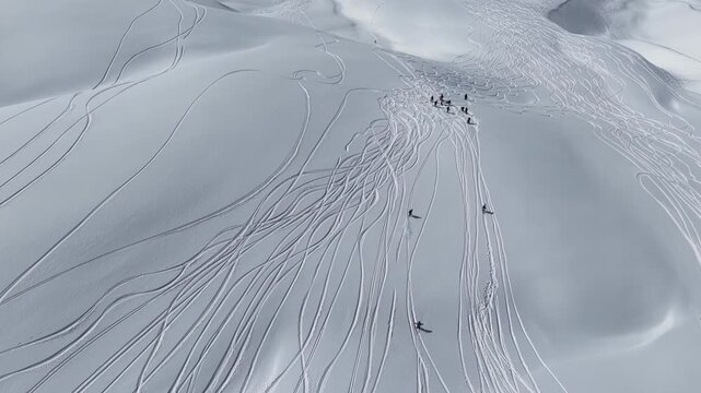 Freeride skiers climbing and descending Bidara peak in Gudauri on deep fresh powder snow, winter adventure in Georgia mountains. Backcountry freeride and skiing untouched powder in snowy mountains.