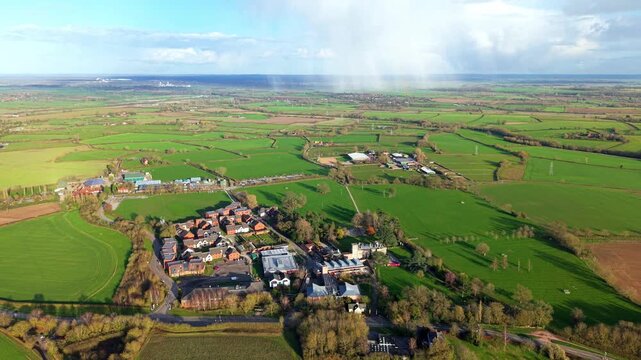 Aerial view of Nottingham Trent University campus nestled amidst vibrant green fields under a partly cloudy sky, Southwell, United Kingdom.