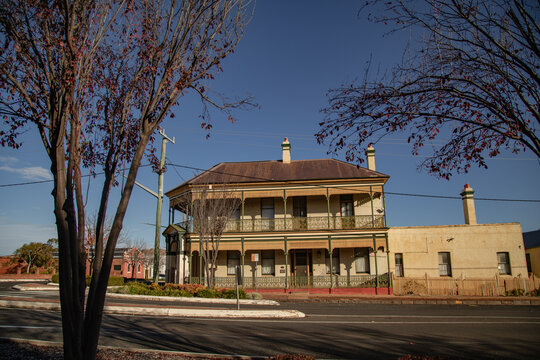 Historic Victorian-era building with ornate verandah and chimneys under a clear blue sky