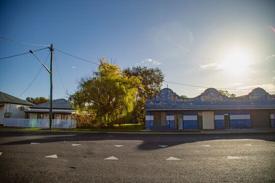 Dilapidated blue building and a small miner's cottage along a quiet street