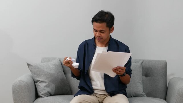 Stressed Asian man feels tired crumple paper and throw, having concentration problem, lack of ideas, writers block, creative crisis, deadline concept