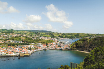 Fototapeta premium Panoramic elevated harbor town vista with lush landscape