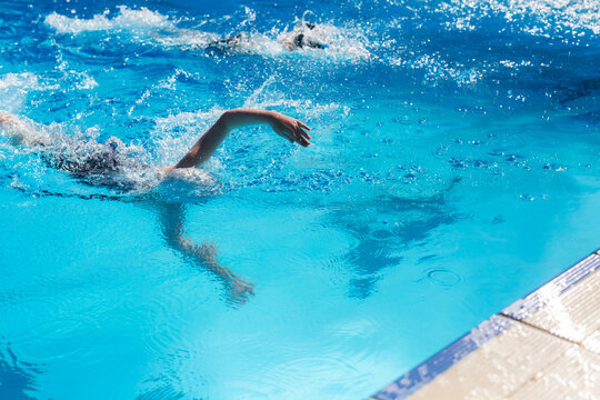 girl reaching for the wall in a competitive swim race (freestyle)