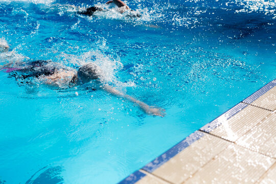 girl reaching for the wall in a competitive swim race (freestyle)