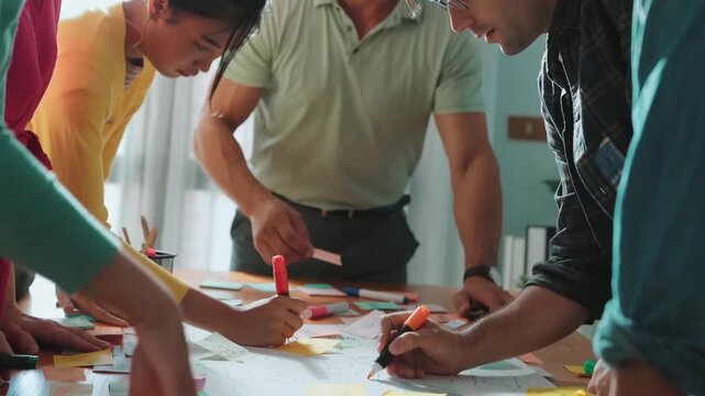 Close up of developer team using mind map to brainstorm idea. Top view of skilled group of business people working together writing marketing strategy by using markers and sticky notes. Symposium.