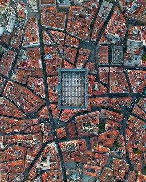 Aerial view of the rectangular Plaza Mayor surrounded by historic red-tiled rooftops and narrow streets in Madrid, Community of Madrid, Spain.