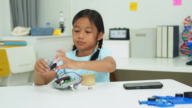 Young girl having fun working on a robot design
