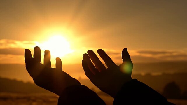 A person's hands reaching up towards the sun during a beautiful sunset video