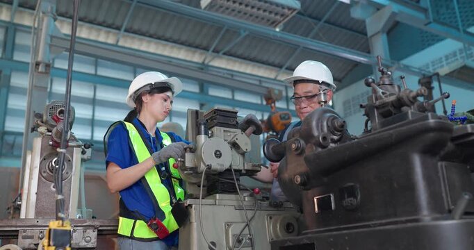 Father passes down machine know-how to his daughter in a family factory, guiding succession, workshop skills and leadership transition through hands-on manufacturing training.
