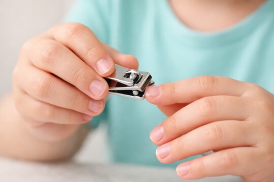 Nail-Care Routine: A person meticulously trims their fingernails, showcasing the simple self-care ritual with a close-up shot of the clippers and nails.