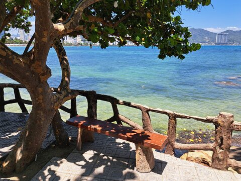 A sunny beach scene in Hon Chong, Nha Trang, Vietnam, with gentle waves washing onto the sandy shore and clear turquoise water. Ideal tropical destination with a relaxing and natural atmosphere.