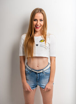 Smiling young woman in crop top and shorts.