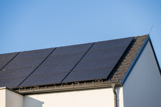 Modern photovoltaic system in black on the roof of a family house