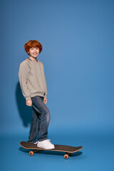 Naklejka premium Stylish boy enjoying a skateboard ride on a vibrant blue background