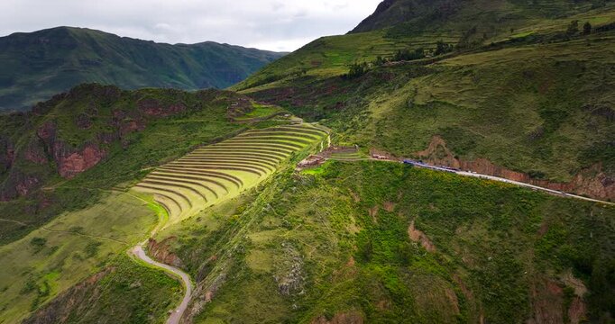Ancient terraces at Pisac in Peru&rsquo;s Sacred Valley, revealing sweeping mountain slopes, winding roads and dramatic highland scenery, cinematic aerial view