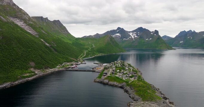 Drone establisher toward Hus&oslash;y island with fishing village in Oyfjorden, Senja